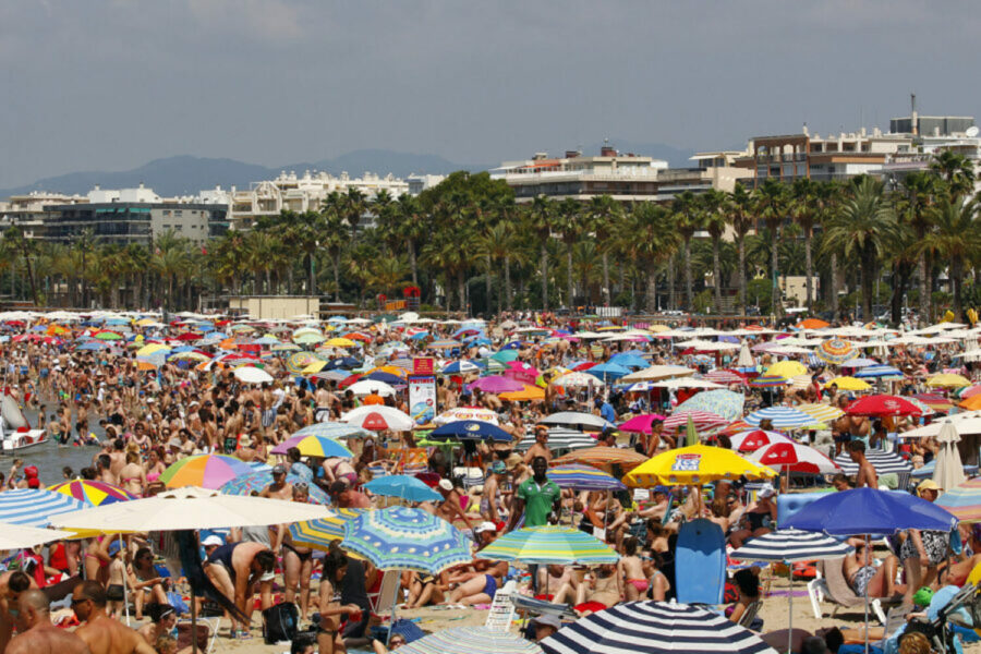 People relaxing and having fun on the beach of Salou, Spain